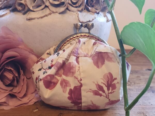 Pink Grey leaf purse 3x4 Handmade vintage-style floral coin purse with an antique bronze kiss-lock clasp, resting on a wooden table beside a dusty pink rose and a ceramic vase.