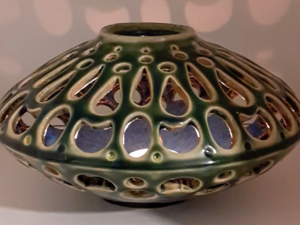 Handmade olive green ceramic lantern with hand-cut teardrop openings