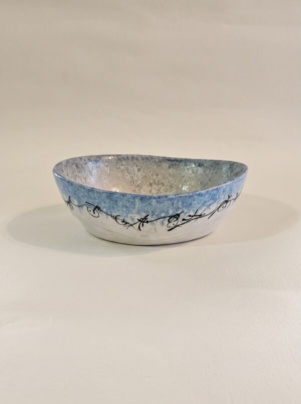 Handbuilt oval ceramic dish with black calligraphic line art on sky blue glaze