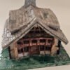 Handbuilt ceramic Tudor-style timber cottage with tiled roof, chimney and green base
